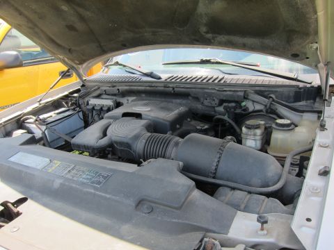 2001 Ford Crown Victoria - Engine bay of a vehicle, with another vehicle partially visible on the left side.