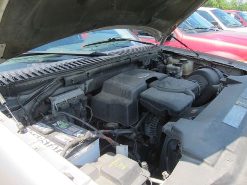 2001 Ford Crown Victoria - The engine bay of a vehicle is shown with the hood up, revealing the engine components and a battery.