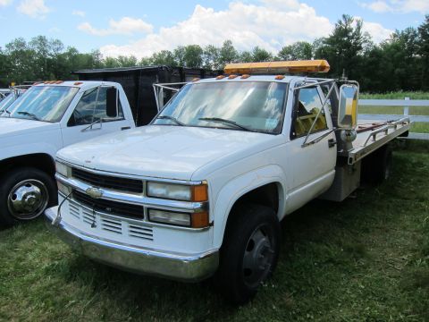 2001 Ford Crown Victoria - A white tow truck, likely a 1995 Chevrolet, is parked on grass with another truck visible to the left.
