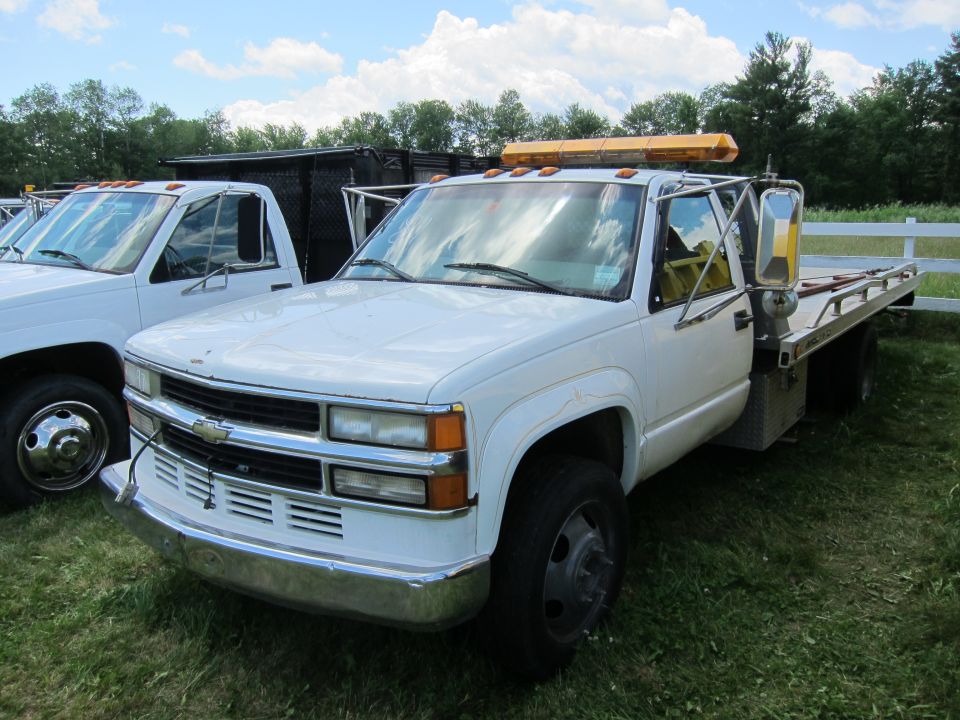 White tow truck with yellow light bar, 3q-front view. Appears to be a 1995 Chevrolet