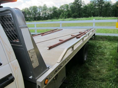 2001 Ford Crown Victoria - Close-up of a tow truck bed, metal ramps and side rails.