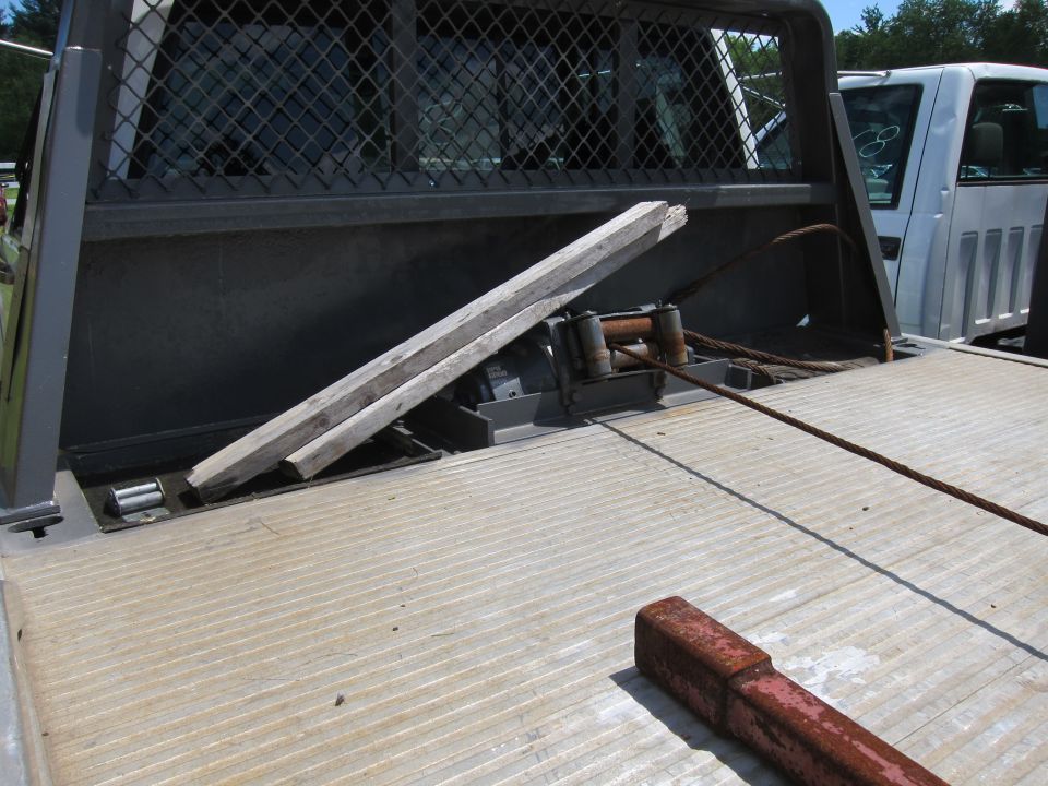 Tow truck bed with winch, cable, and wooden ramps