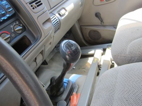 2001 Ford Crown Victoria - The interior of a truck displays a manual transmission shifter and dashboard controls.