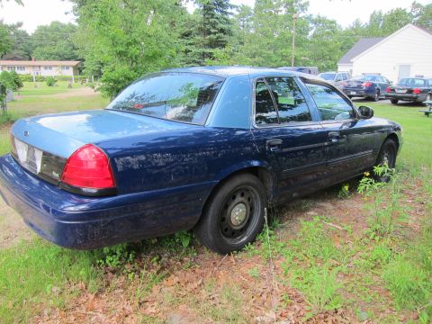 2001 Ford Crown Victoria - Blue 2001 Ford Crown Victoria parked outdoors with other vehicles in the background.