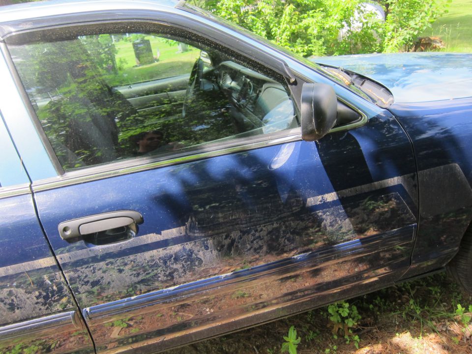 2001 Ford Crown Victoria side view, blue paint with dirt streaks on doors