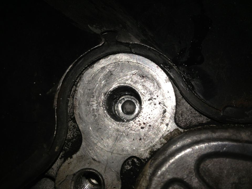 Close-up of engine timing belt cover with visible bolt holes and gasket