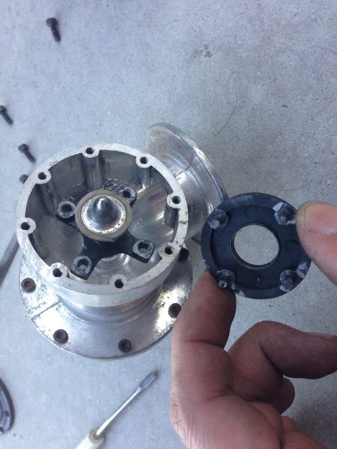 1996 Ford Probe - A disassembled wheel hub component is shown, with screws and a black gasket held by a hand.