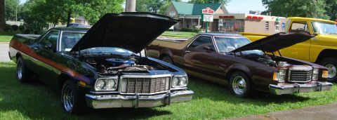 1975 Ford Ranchero - Two Ford Rancheros and a yellow pickup truck are parked on a grassy area with their hoods open.