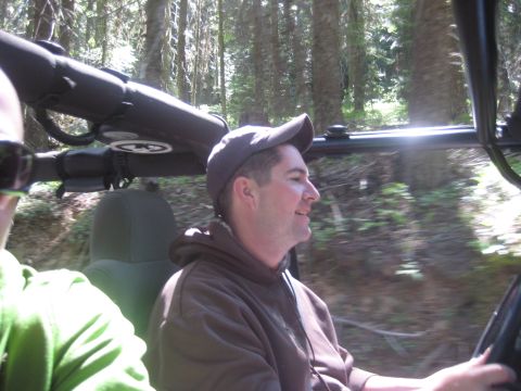 2005 Jeep Wrangler - Two people are enjoying a drive through a wooded area in a jeep.