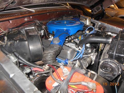 1979 Ford F-150 - The engine bay of a 1979 Ford F-150 shows a blue air cleaner assembly and a red battery.