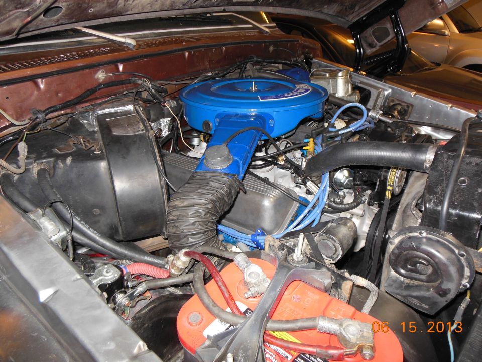 1979 Ford F-150 engine bay with a blue air cleaner and red battery
