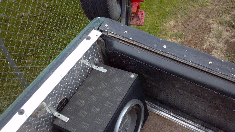 Passenger rear corner.  You can see where I screwed in snap studs to my tailgate cover, rather than drilling into the sheet metal itself.