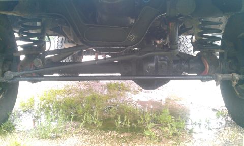 1987 Ford Bronco - The underside of a vehicle is captured, revealing its suspension and mechanical parts.