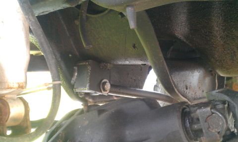 1987 Ford Bronco - Close-up view of the undercarriage, highlighting suspension parts and the rear differential. The Supermotors.net logo is visible.