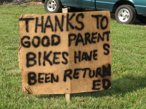 1994 Ford Bronco - A handmade sign thanks parents for the return of bikes, with a teal truck visible in the background.