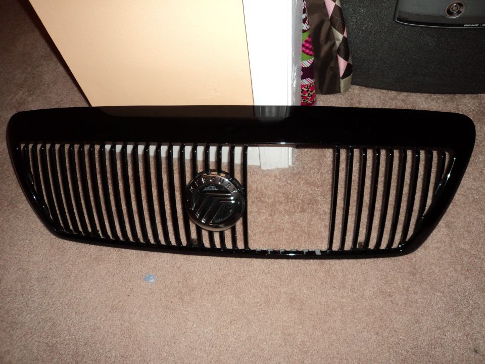 Black vertical slat grille with a circular Mercury emblem