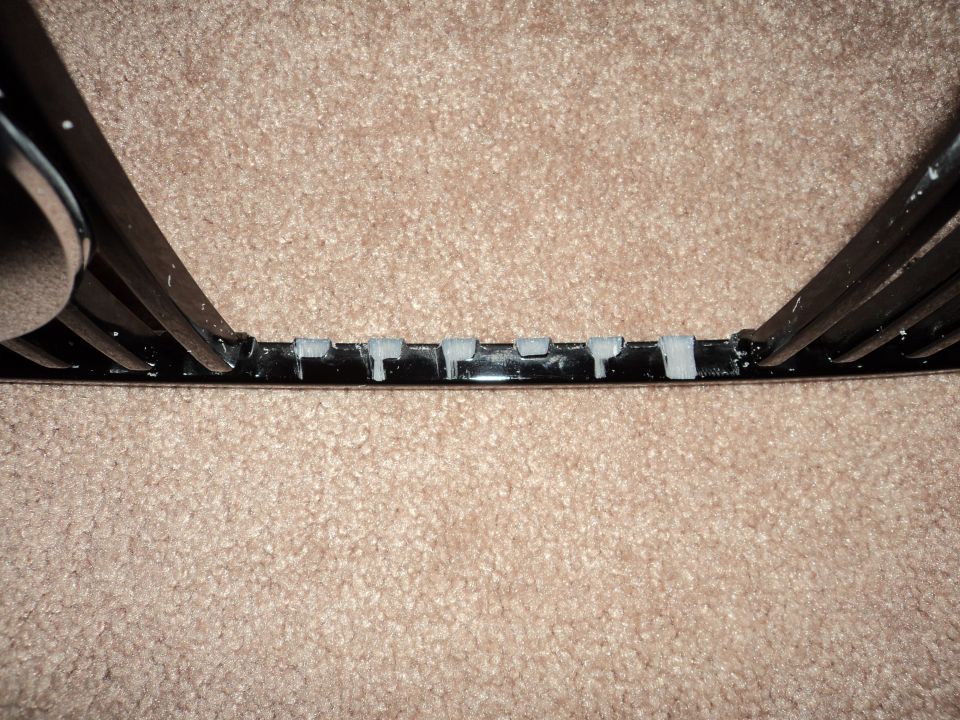 Black grille with chrome trim and grey clips, part of a 2004 Mercury Grand Marquis