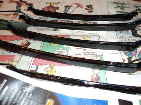 2004 Mercury Grand Marquis - Several black car trim pieces are arranged on a surface covered with newspaper.