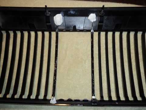 2004 Mercury Grand Marquis - Close-up of a car's black grille, showing vertical slats and adhesive used for mounting.