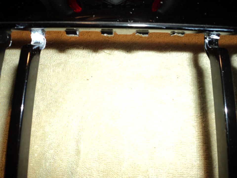 close-up of car grille with chrome trim and mounting holes