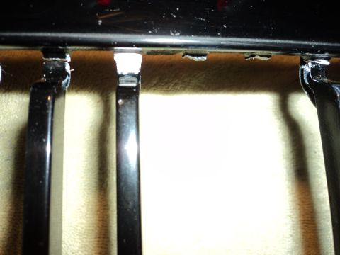 2004 Mercury Grand Marquis - Detail shot of a car's black grille, showing the mounting hardware and bars.