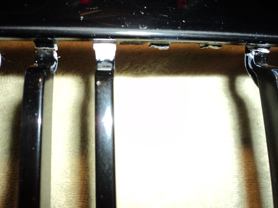 Black grille with vertical bars and visible mounting points