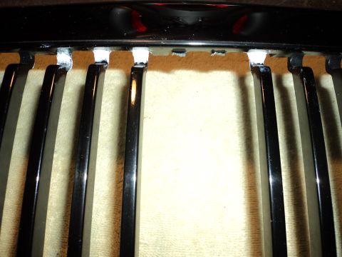 2004 Mercury Grand Marquis - Close-up of a car grille, likely from a 2004 Mercury Grand Marquis, showing mounting points.