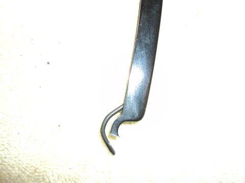 2004 Mercury Grand Marquis - A close-up view of a damaged black metal trim piece, possibly for a vehicle.