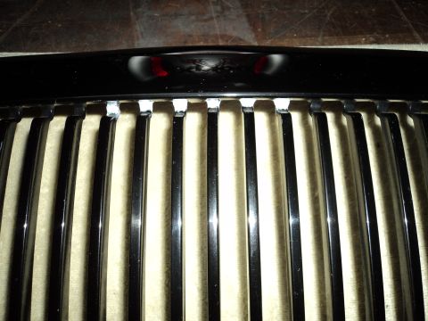 2004 Mercury Grand Marquis - Close-up view of a chrome grille with vertical bars and a black top trim piece. Text from Supermotors.net is visible.