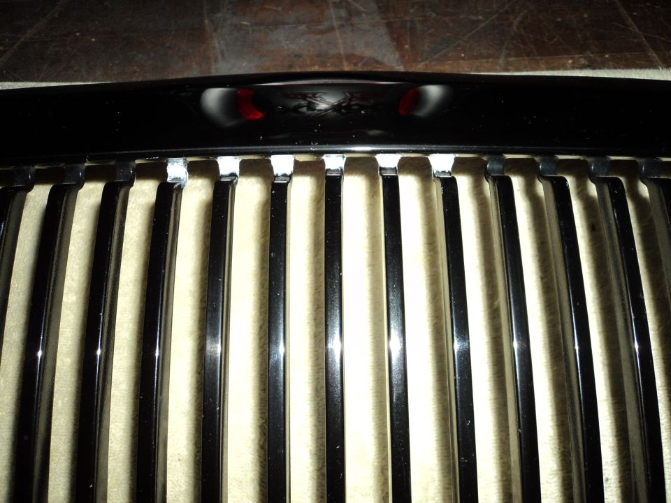 Chrome grille with vertical bars and a black top trim piece