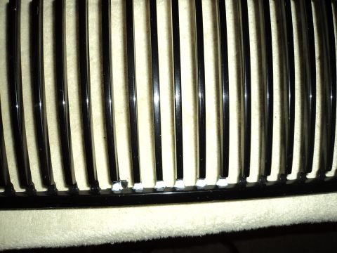 2004 Mercury Grand Marquis - Close-up view of a vehicle's black grille with vertical chrome bars.