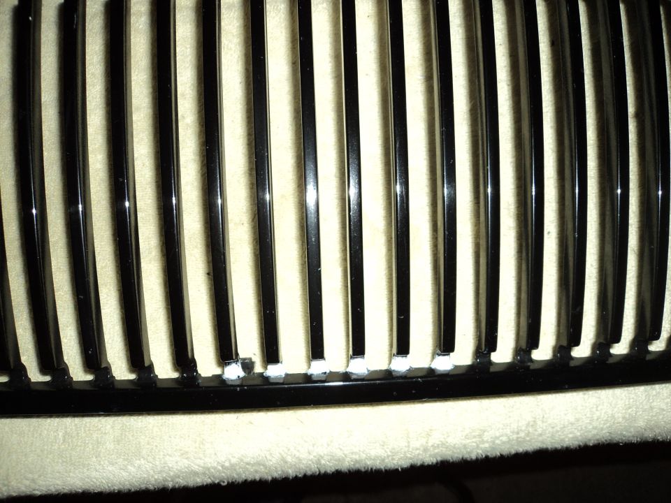 Close-up of a black grille with vertical chrome bars