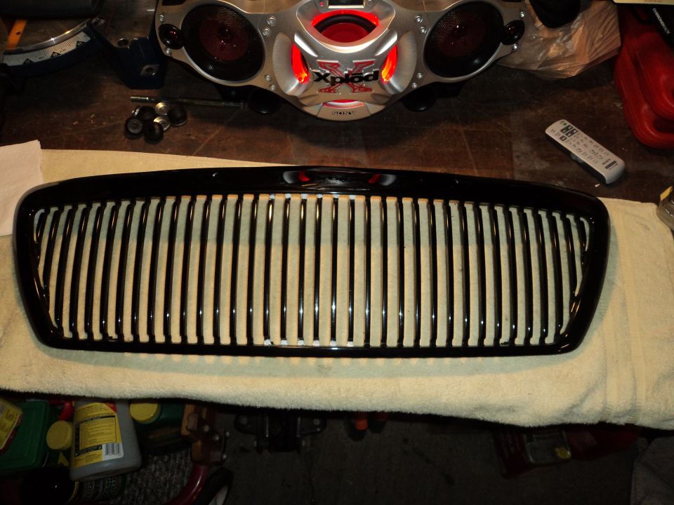 Black vertical slat grille on a towel, with a car stereo and remote in background