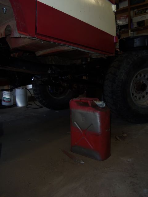 1968 Ford Bronco - The underside of a vehicle with large tires and a red jerrycan is visible in a garage setting.
