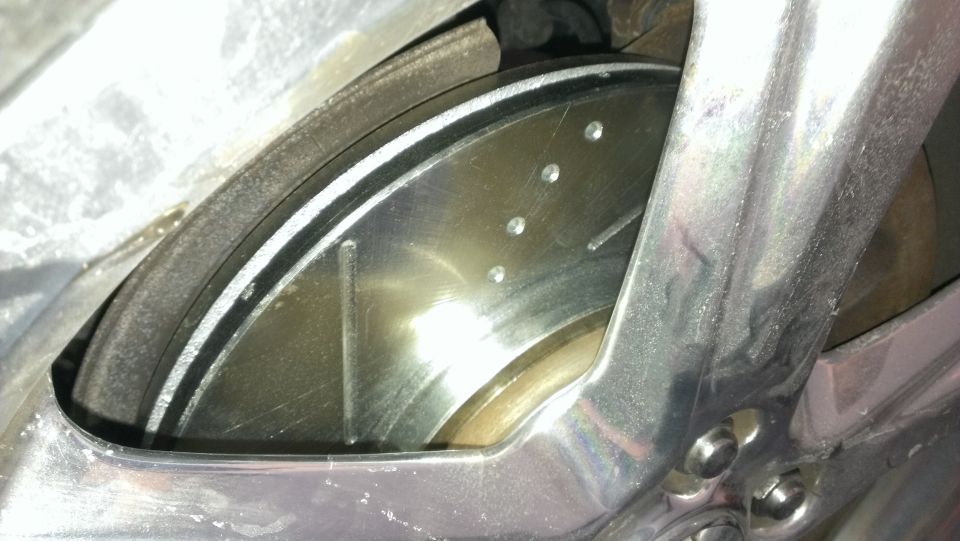 Close-up of a slotted brake rotor with caliper visible