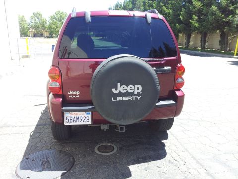 2005 Chevrolet Venture - The rear of a red Jeep Liberty SUV is shown, a spare tire mounted on the back door.