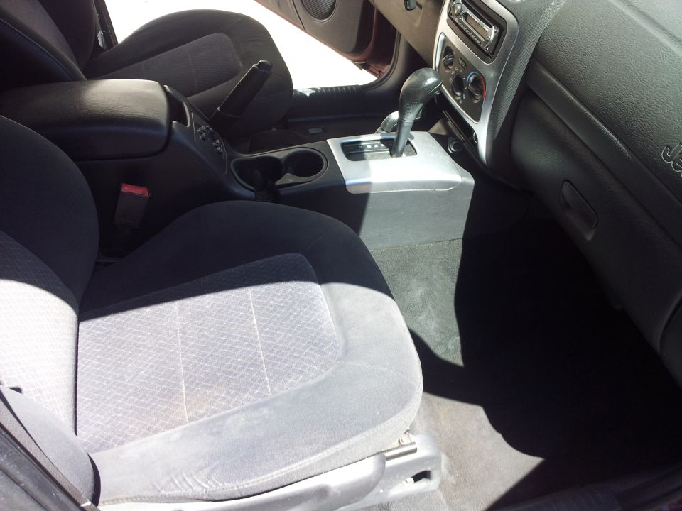 Interior view of a car, showing front seats, center console with gear shifter, and dashboard