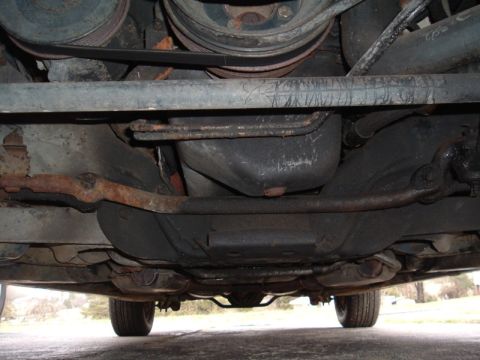 1991 Ford LTD Crown Victoria - A look at the undercarriage of a vehicle, revealing its mechanical components and signs of wear.
