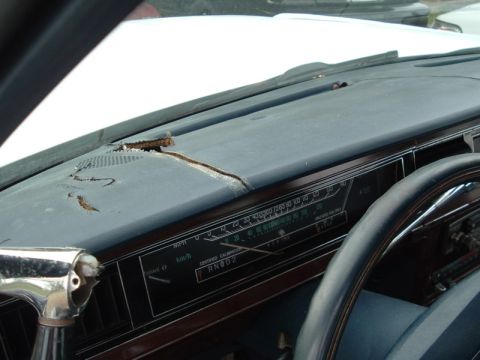 1991 Ford LTD Crown Victoria - The interior of a vehicle shows a cracked dashboard and a portion of the steering wheel and instrument panel.