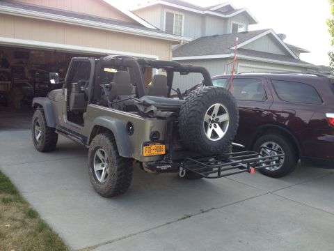 2005 Jeep Wrangler - A tan 2005 Jeep Wrangler is parked in a driveway with a hitch hauler attached to the rear.