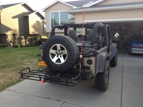 2005 Jeep Wrangler - This 2005 Jeep Wrangler is equipped with a rear hitch hauler and spare tire, seen from the back.