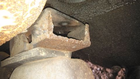 1979 Ford Bronco - Close-up view of a heavily rusted frame bracket on a 1979 Ford Bronco, indicating significant wear and tear.
