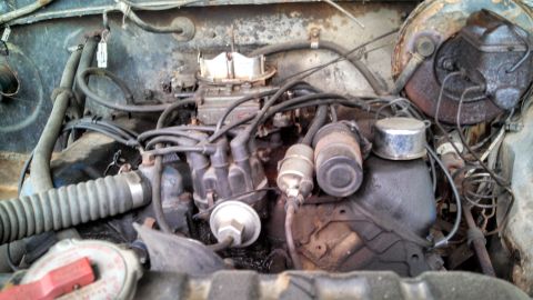 1979 Ford Bronco - Close-up view of the engine compartment, showing the carburetor and ignition system components.