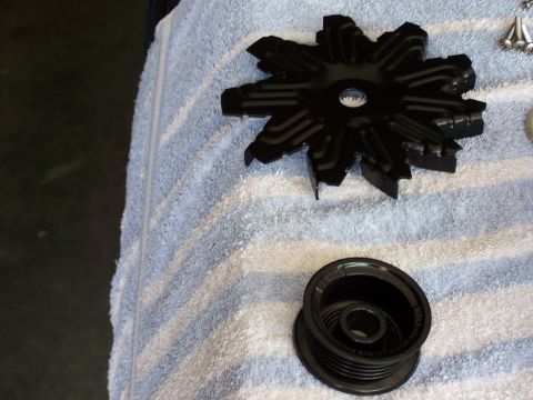 1991 Ford LTD Crown Victoria - Two automotive parts, a fan blade and a pulley, are laid out on a towel.