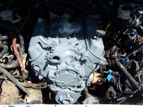 1991 Ford LTD Crown Victoria - The engine is partially disassembled and painted gray, with various hoses and electrical components visible around it.