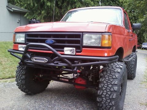 1989 Ford Bronco - This lifted Ford truck features a custom front bumper with a winch and large off-road tires.
