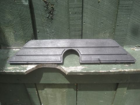 1993 Ford Bronco - This dark gray plastic trim piece features a semicircular cutout and horizontal ridges.