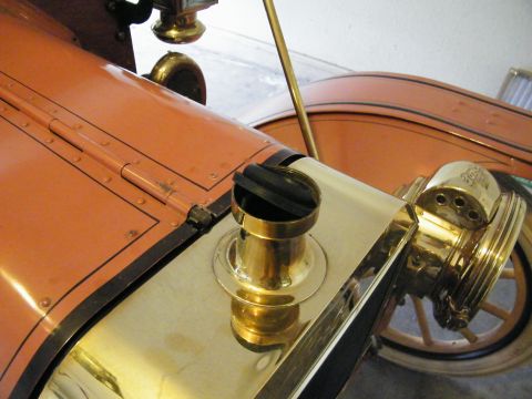 1912 Ford Model T - The brass radiator cap and headlight are prominent features on this antique vehicle's hood.