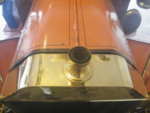 1912 Ford Model T - Close-up of the orange hood and brass radiator, the Ford script, on a 1912 Model T.