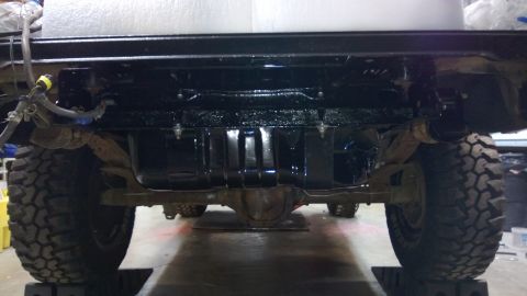 1983 Ford Bronco - Undercarriage view shows a large fuel tank and heavy-duty tires, suggesting an off-road vehicle.